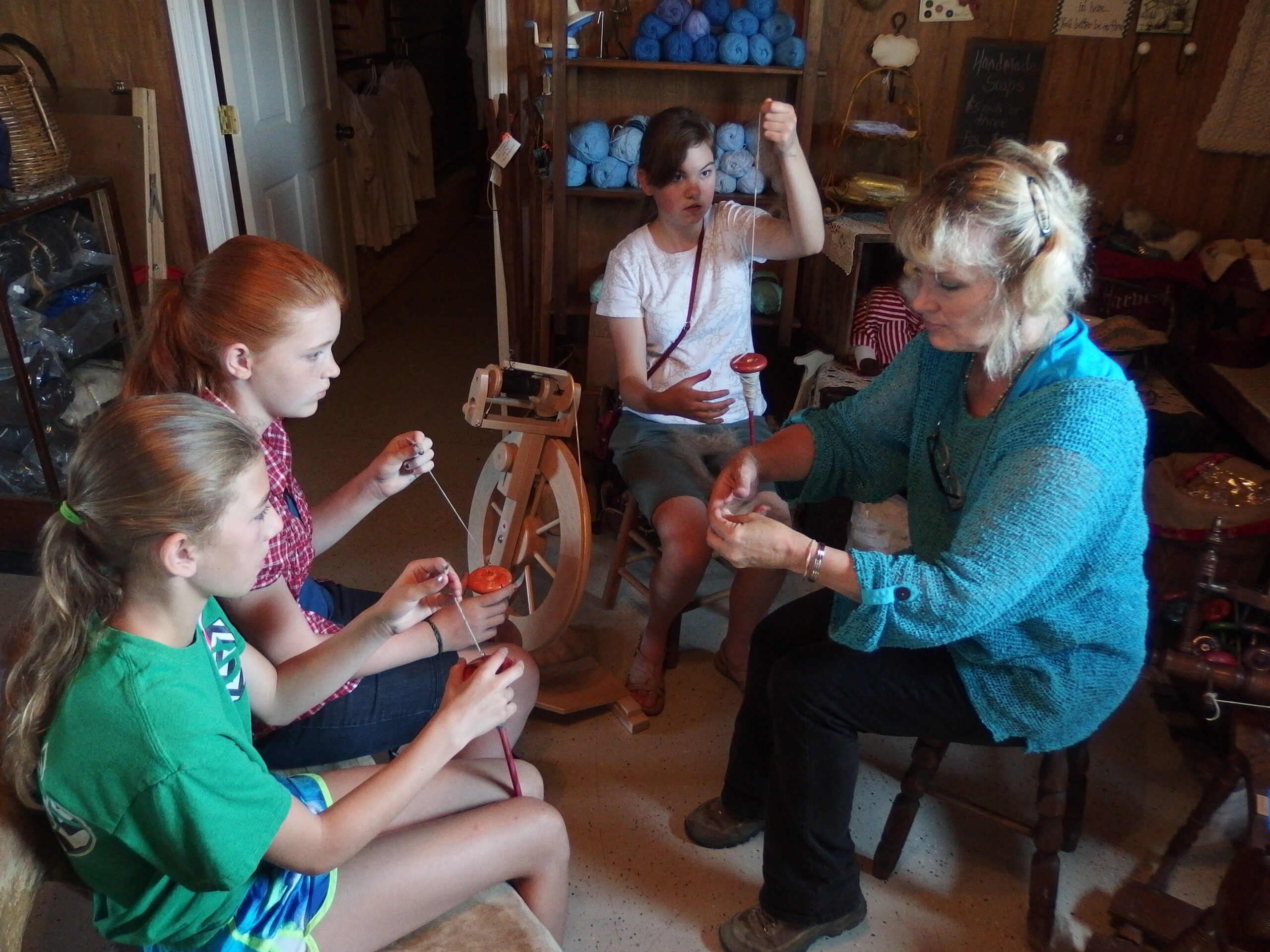 Kids learning to spin llama fiber into yarn